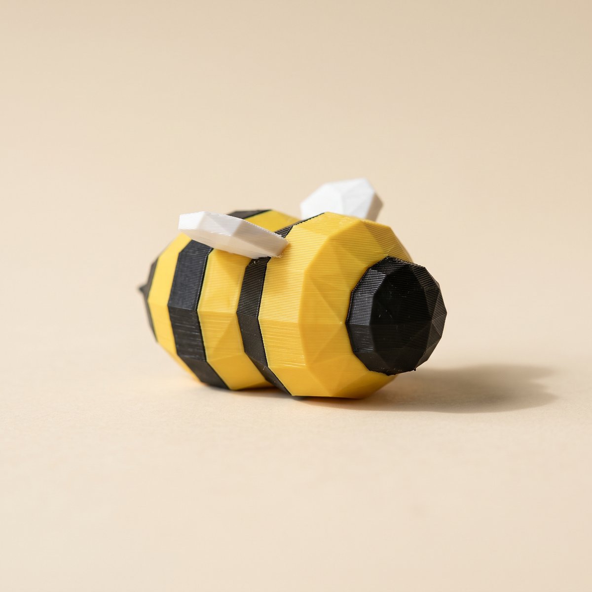 Yellow and black 3D-printed bee figurine, the color pairing where K2 Plus color bleed shows first