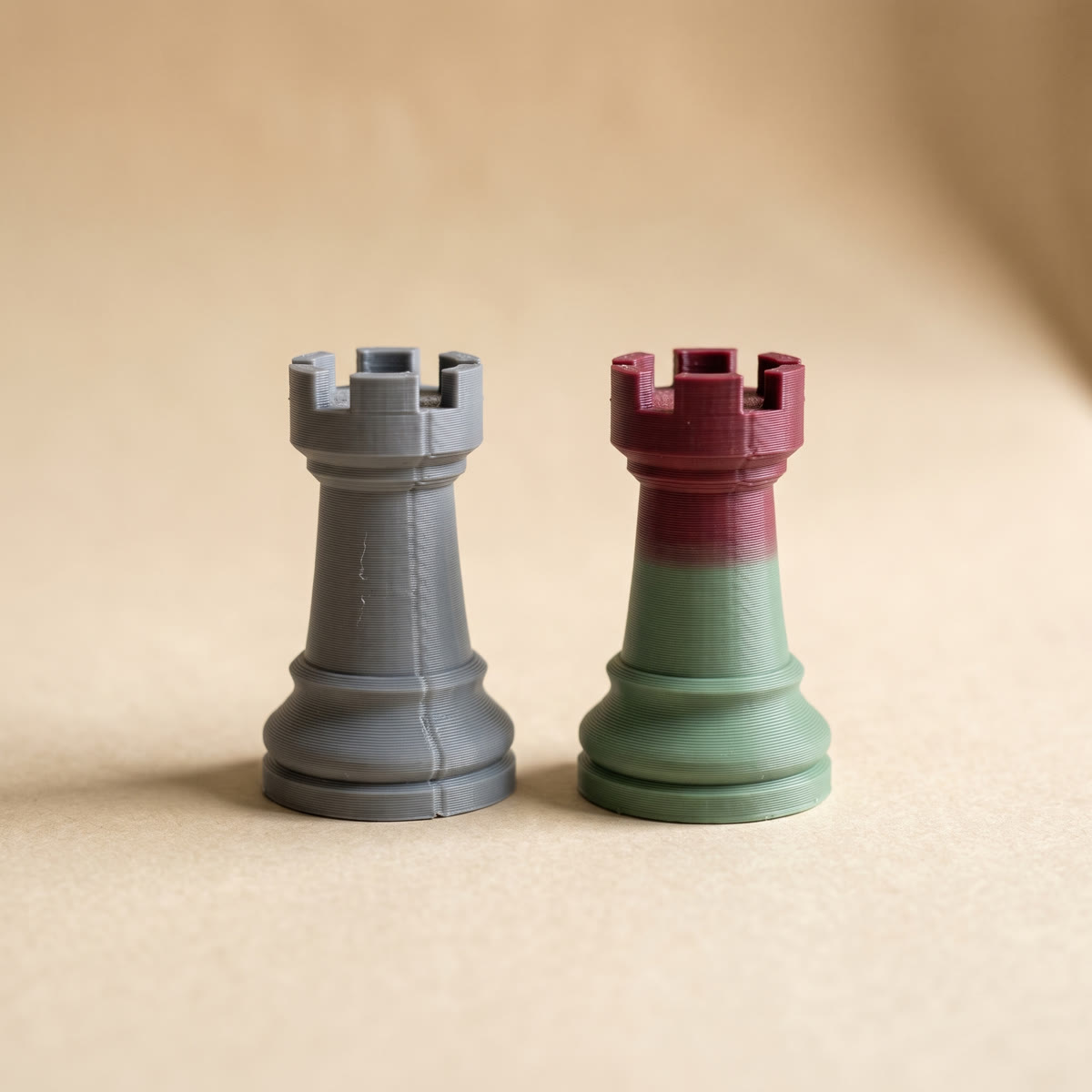 Two 3D printed chess rooks compared, a two-tone multicolor print next to a grey model that came out one color after slicing
